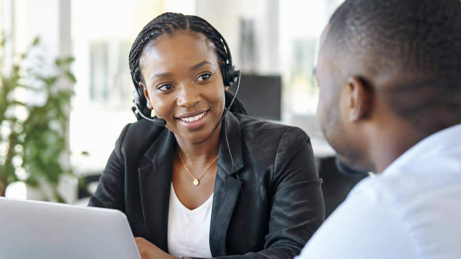 Profissional africana a atender um cliente no escritório.